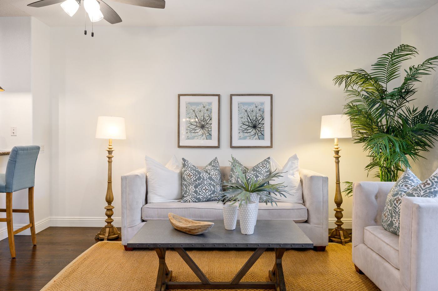 Bright, spotless living room with white sofas and a tidy coffee table
