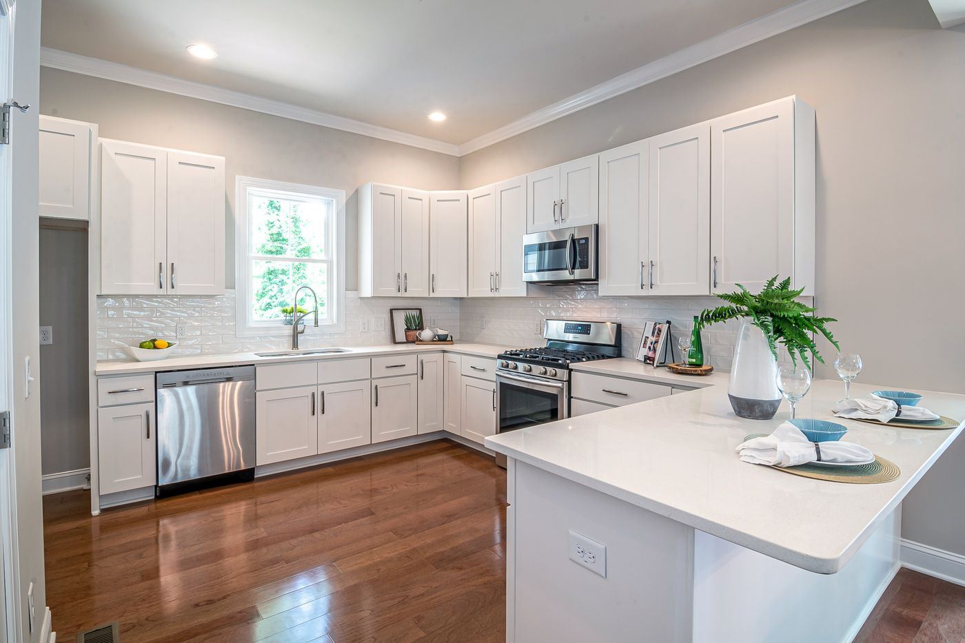 Spotless white kitchen with clean countertops and stainless appliances